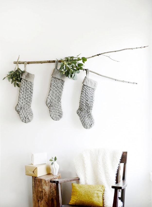 Christmas Stocking Holder Ideas for a Cozy Display Without a Fireplace featuring a stockings hanging from a rustic branch in scandi style