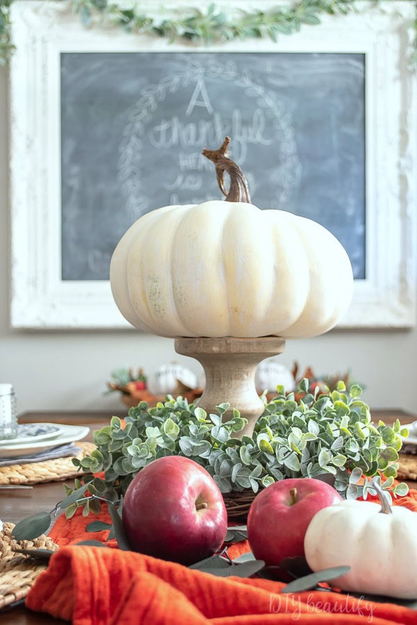 Vignette showcasing transition from Thanksgiving to Christmas decor with a floral arrangement