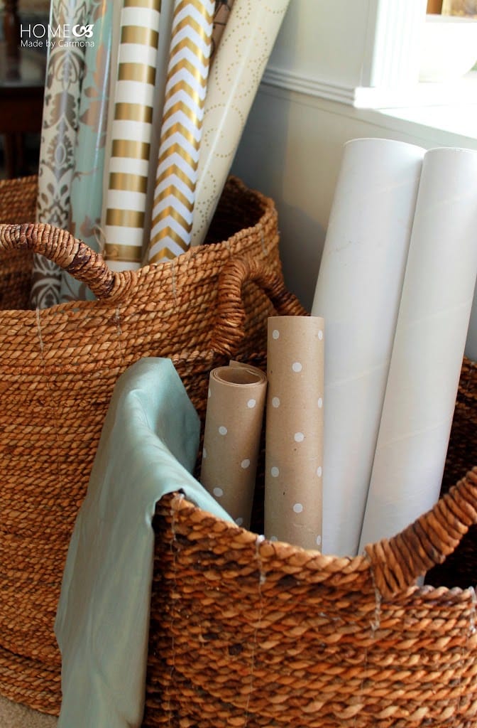 Gift wrapping station ideas for the holidays featuring a wrapping paper rolls on baskets