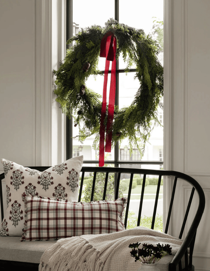 Christmas Wreath idea featuring a dark green wreath above a modern rustic sofa