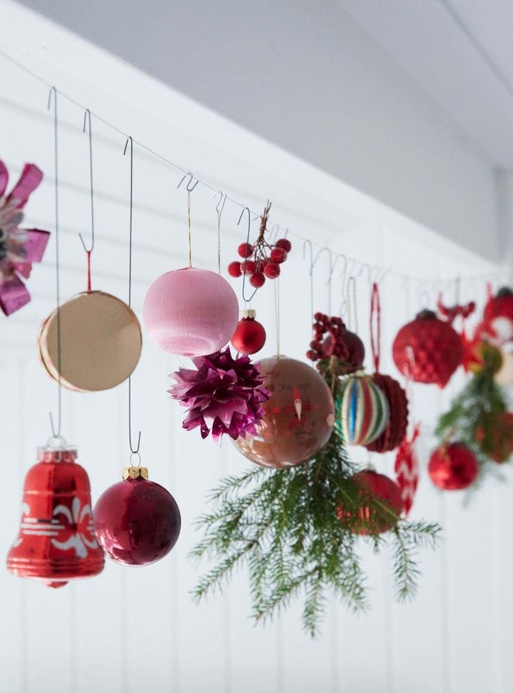Kid-friendly Christmas decor ideas example featuring ornament garland hanging above a bay window nook