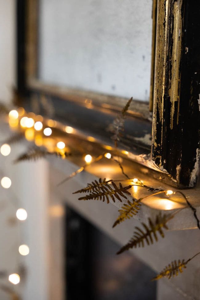 Thanksgiving to Christmas decor idea featuring fairy lights against mirror