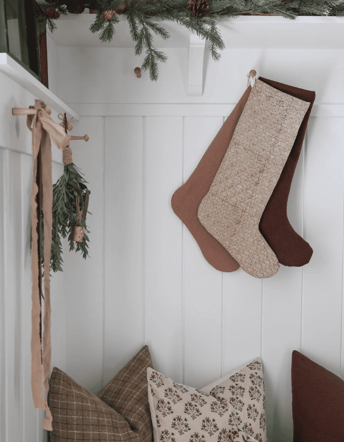 Christmas Stocking Holder Ideas for a Cozy Display Without a Fireplace featuring a stockings hanging from hooks on wall in vintage inspired holiday style