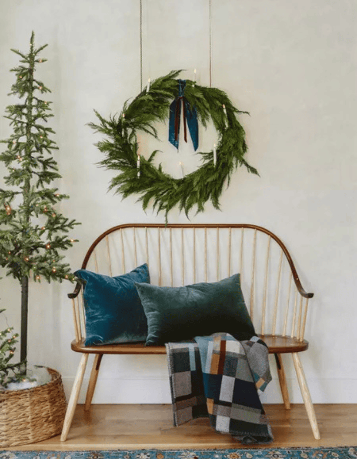Christmas Wreath idea featuring a dark green wreath above a modern rustic sofa