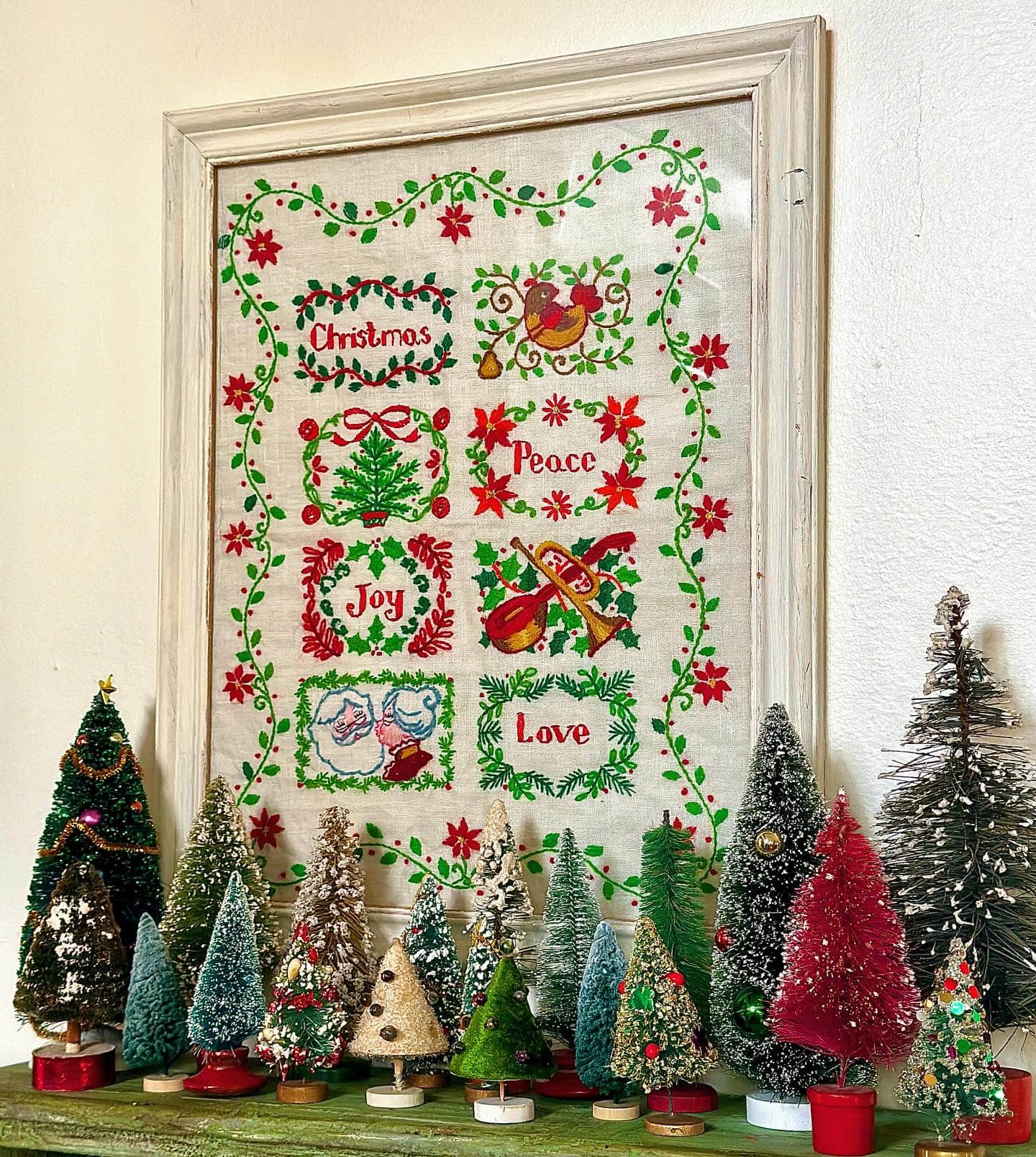 Nostalgic holiday decor idea featuring small brush vintage Christmas tree in a collection scene in red and green