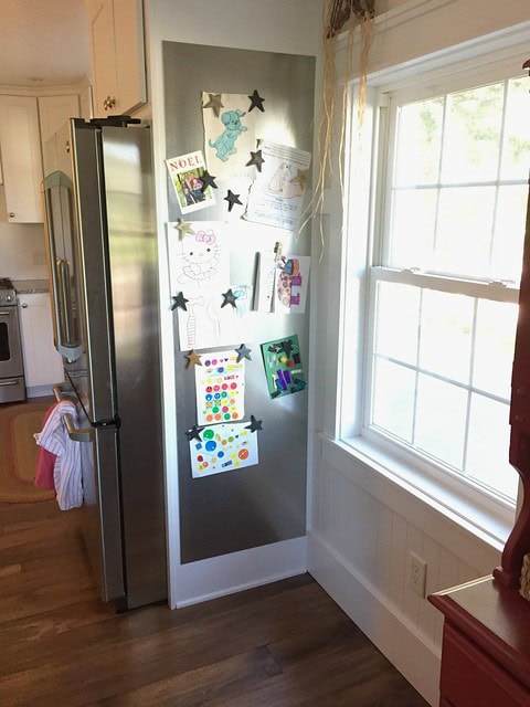 Ideas to display your kids' holiday artwork around the home featuring a collection of artwork attached to the fridge