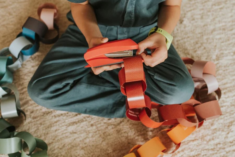 family Christmas traditions idea featuring child making paper chain