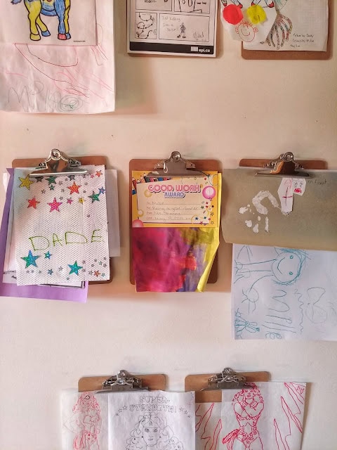 Ideas to display your kids' holiday artwork around the home featuring hanging drawings from clipboards