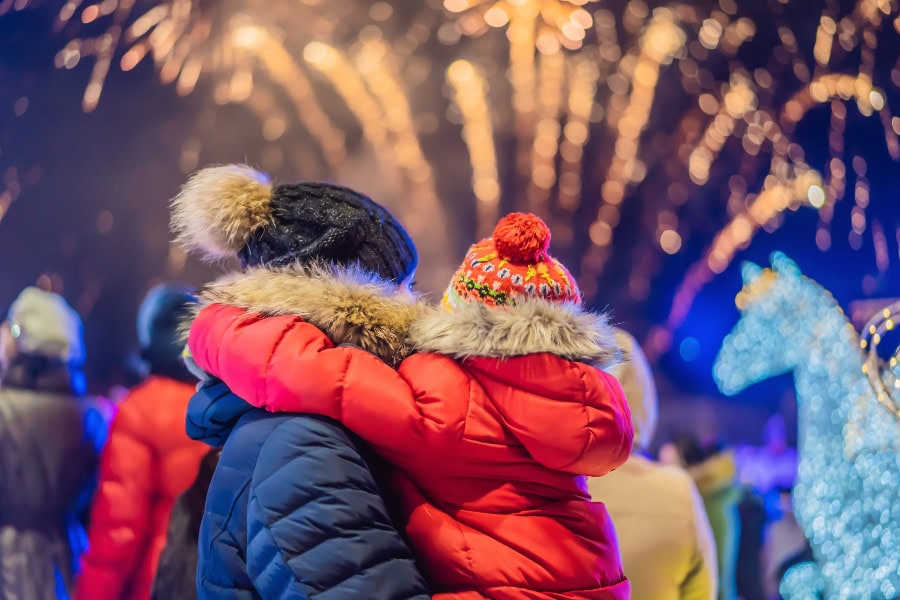 family Christmas traditions idea featuring parent and child watching fireworks during holiday