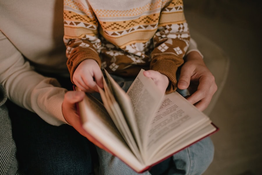 family Christmas traditions idea featuring child reading Christmas stories