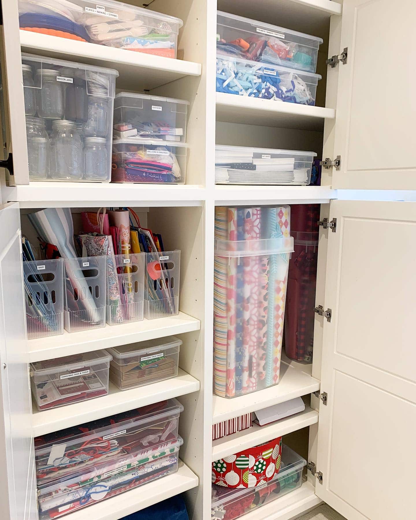 Holiday decor storage ideas featuring a shelving unit with clear boxes holding holiday decorations