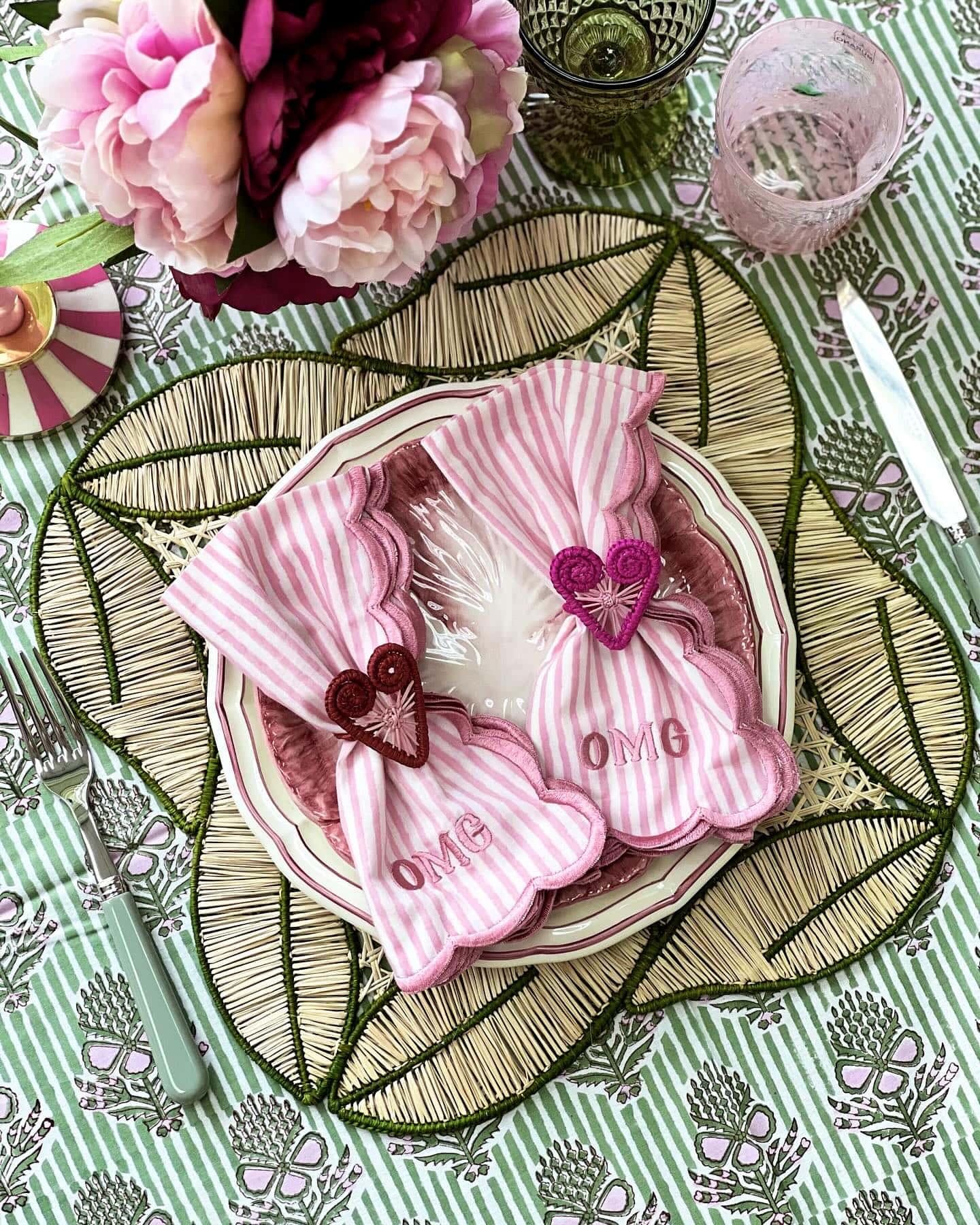 Valentines Day Brunch idea featuring a tablescape in pink and red hues with pink striped napkings