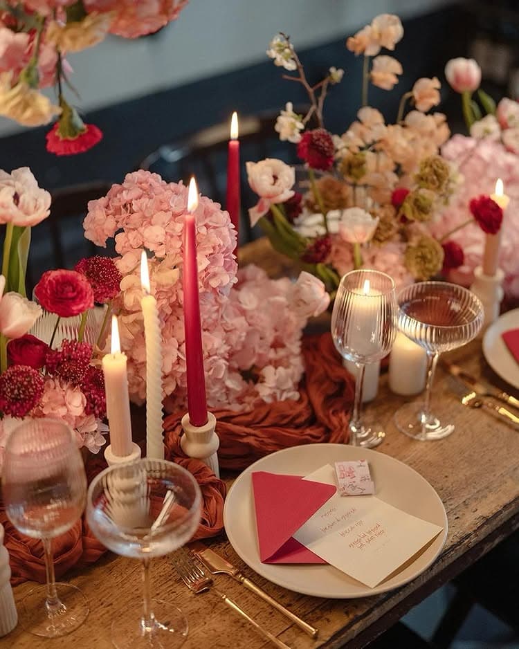 Valentines Day Brunch idea featuring a tablescape in pink and red hues with long tapered candles