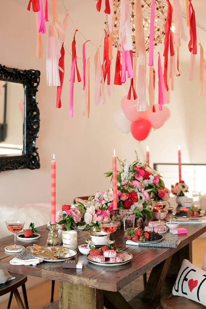 Valentines Day Brunch idea featuring a tablescape in pink and red hues with long tapered candles