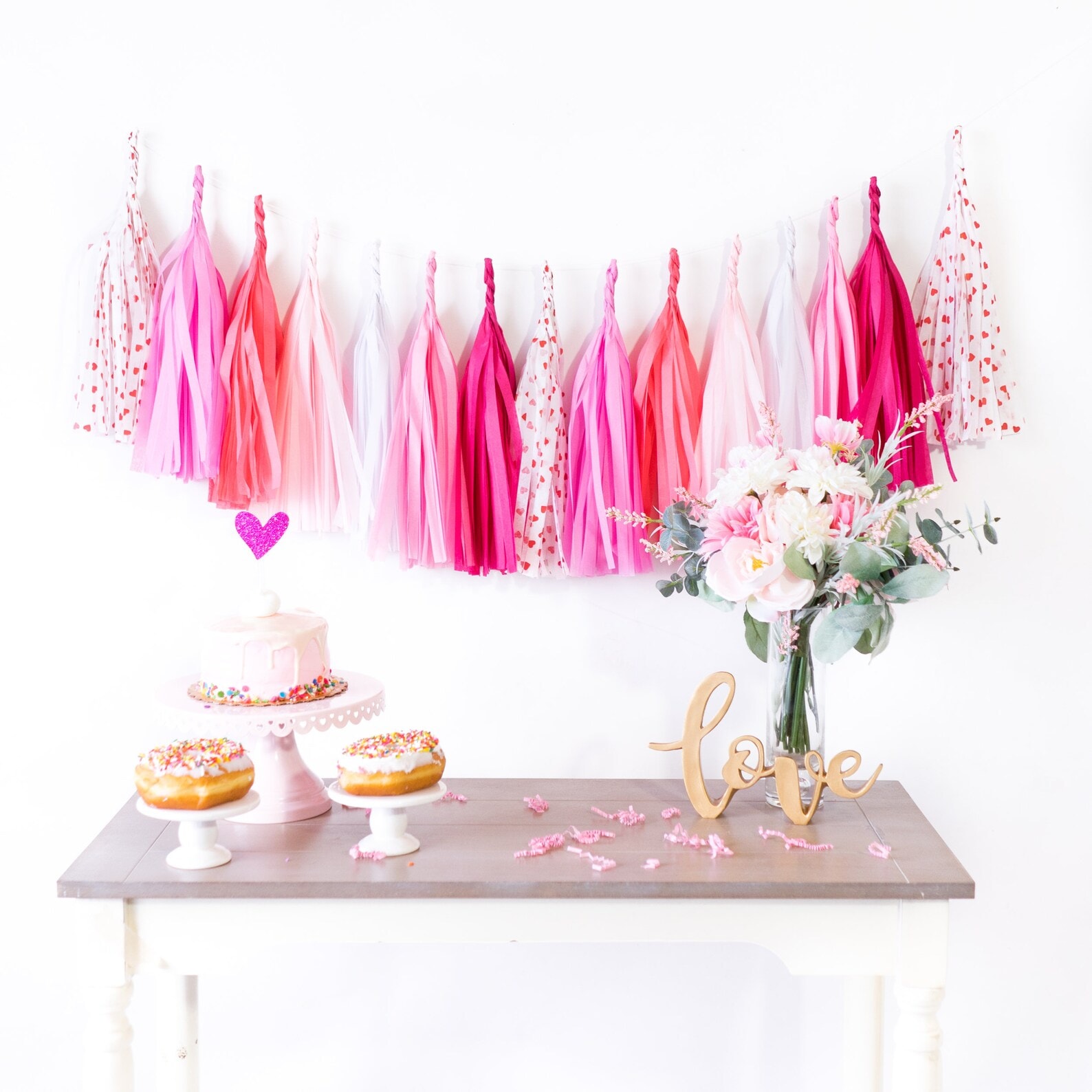 Example of Valentine’s Day kids dessert table featuring kid-friendly sweet treats in vibrant colors with on-themed decor around