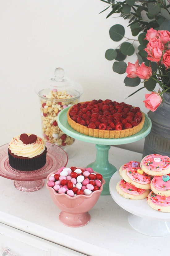 Example of Valentine’s Day kids dessert table featuring kid-friendly sweet treats in vibrant colors with on-themed decor around