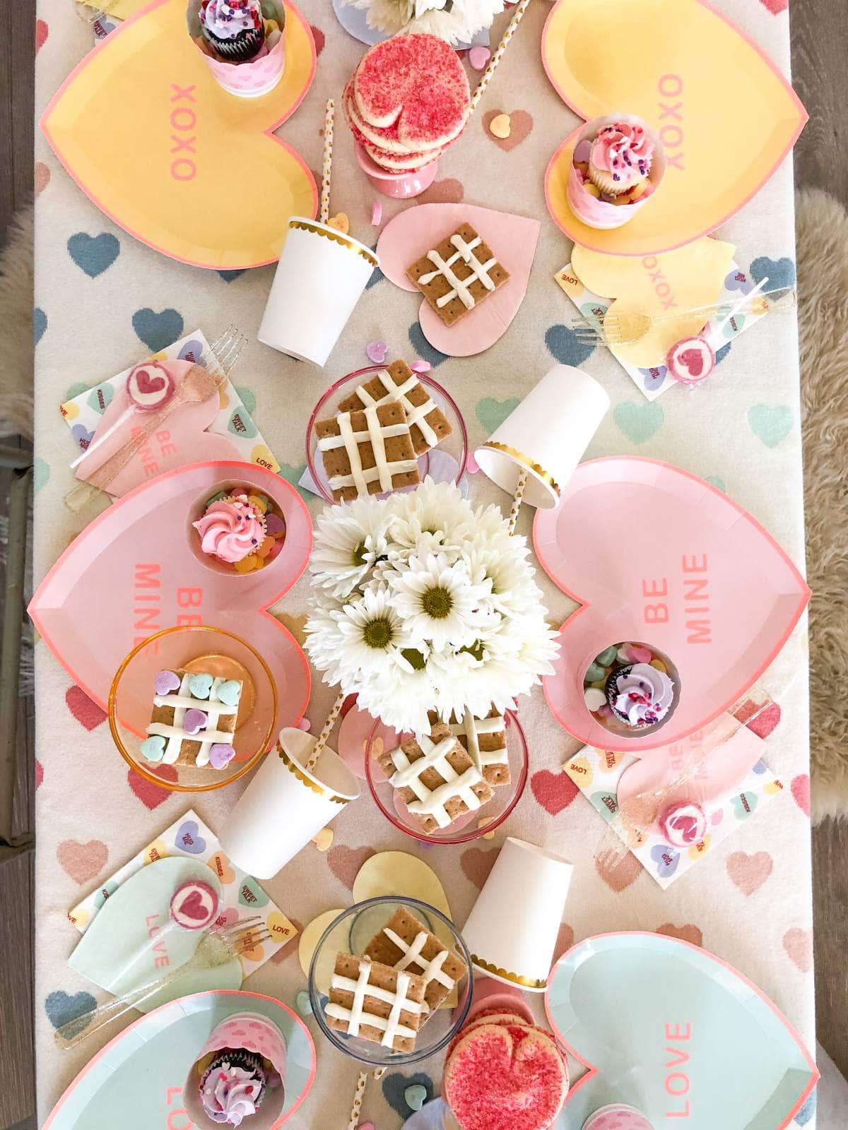 Example of Valentine’s Day kids dessert table featuring kid-friendly sweet treats in vibrant colors with on-themed decor around