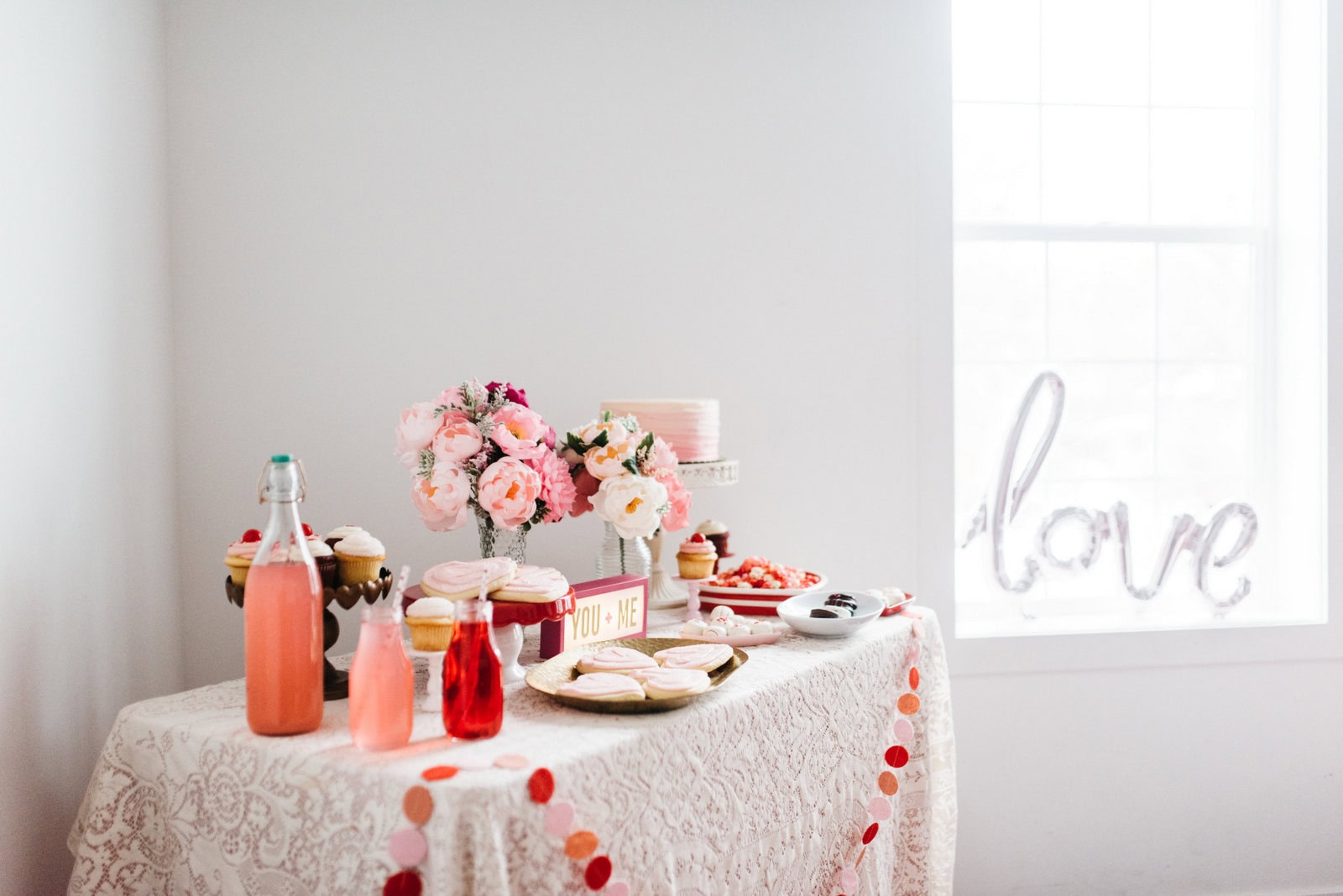 Example of Valentine’s Day kids dessert table featuring kid-friendly sweet treats in vibrant colors with on-themed decor around