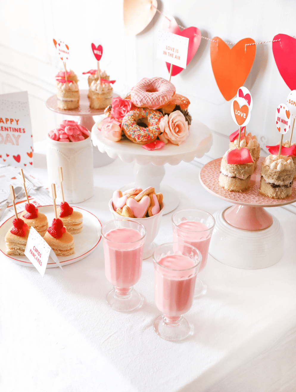 Example of Valentine’s Day kids dessert table featuring kid-friendly sweet treats in vibrant colors with on-themed decor around