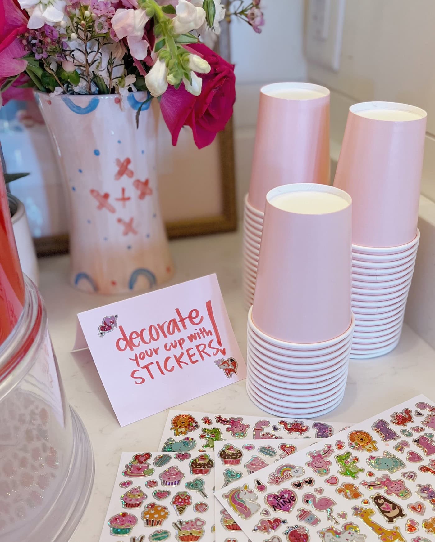 Example of Valentine’s Day kids dessert table featuring kid-friendly sweet treats in vibrant colors with on-themed decor around