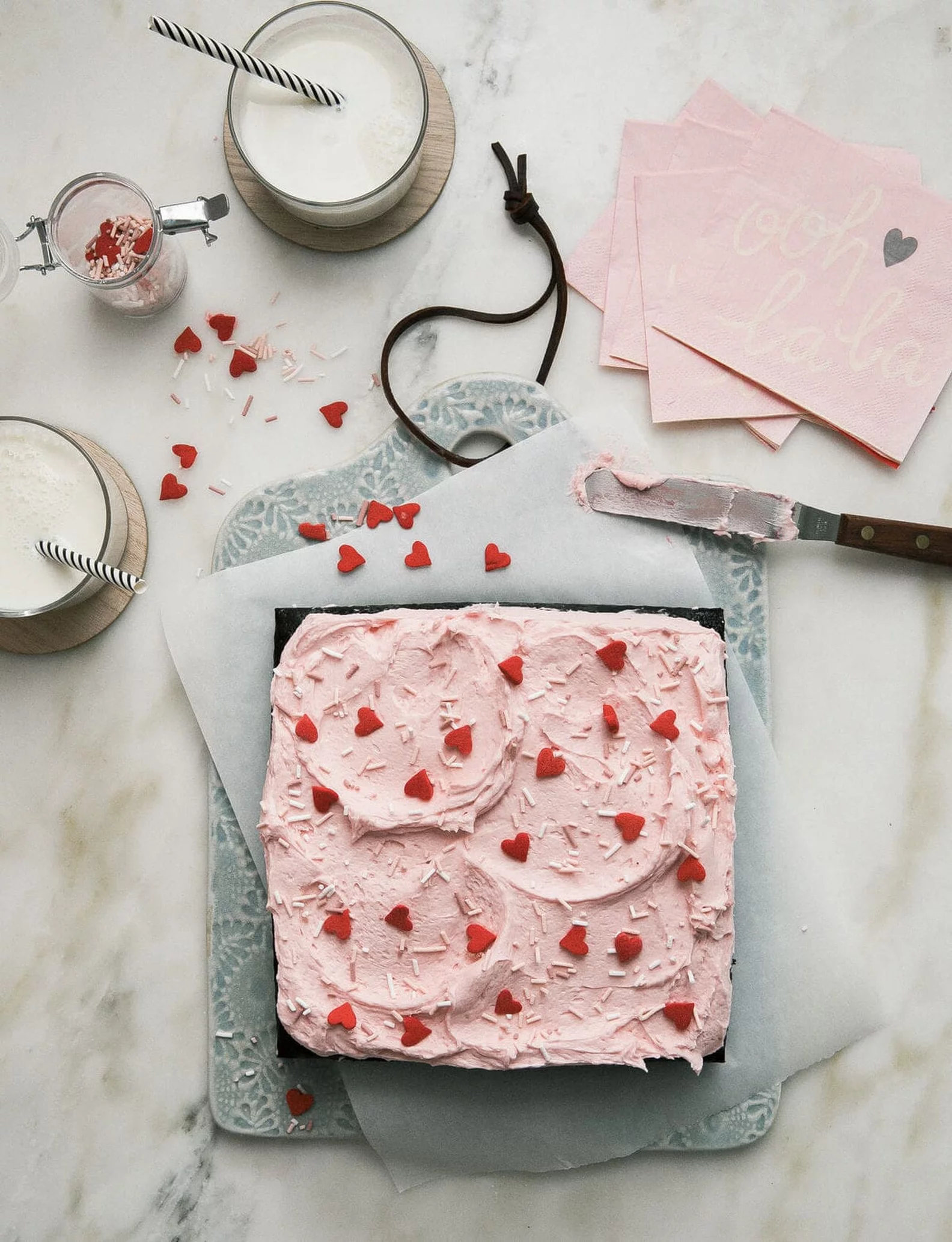 Example of Valentine's day kids dessert table featuring kid-friendly sweet treats in vibrant colors with on-themed decor around