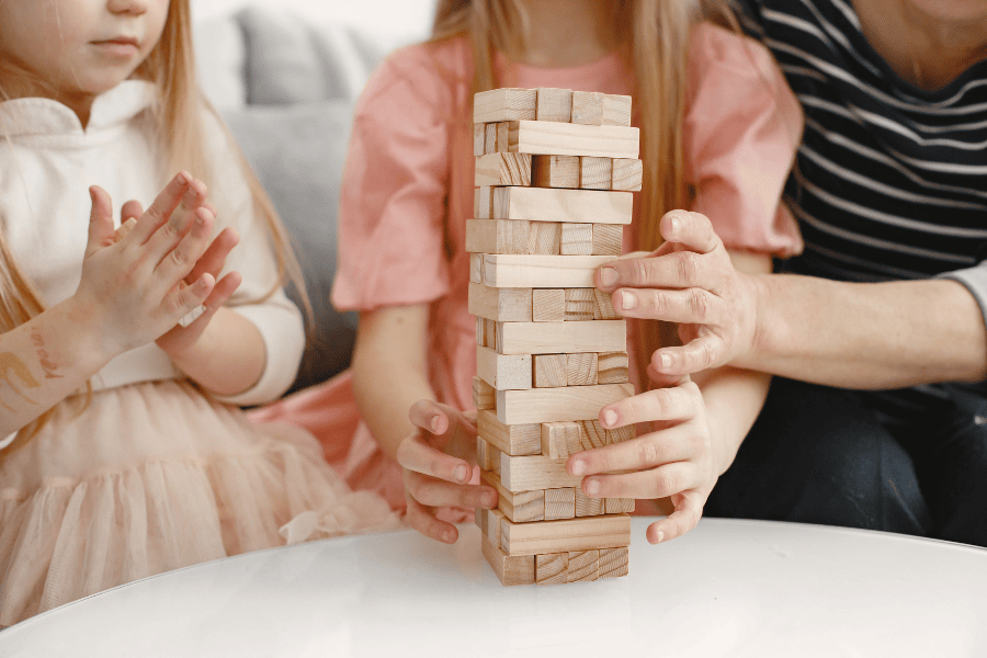 Celebrating New Year's eve with kids featuring a child having fun playing Jenga