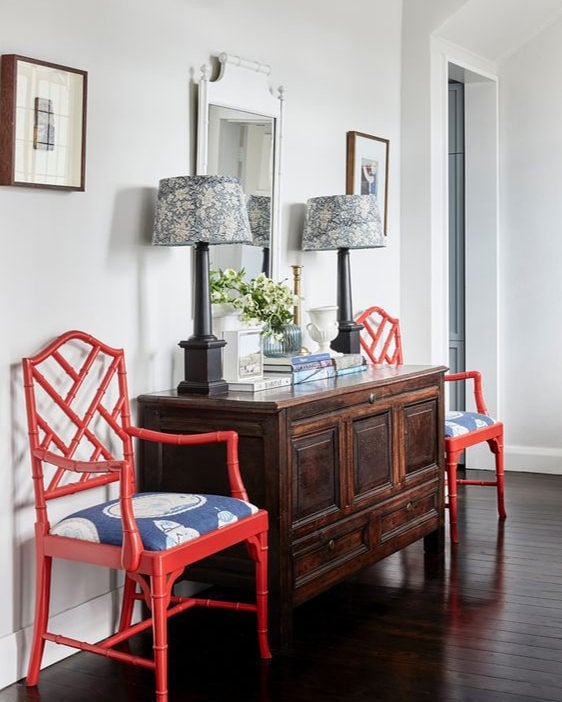 Home design trends 2025 idea featuring a entryway with red chairs as unexpected red theory accents