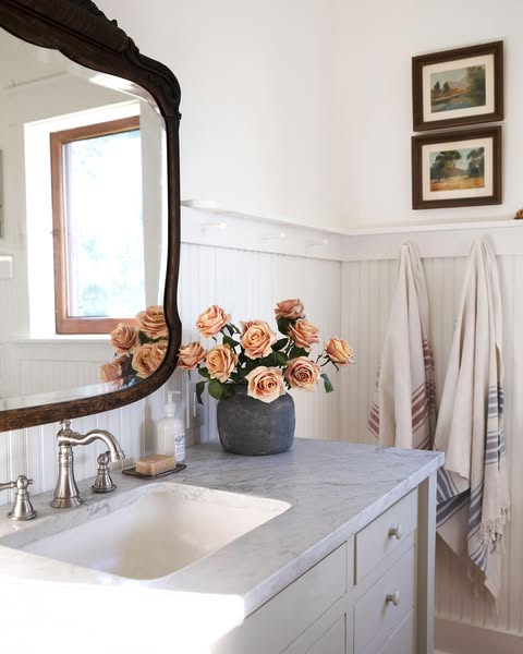 Example of how to use mirrors and lighting to enhance a space featuring a bathroom with a antique mirrors
