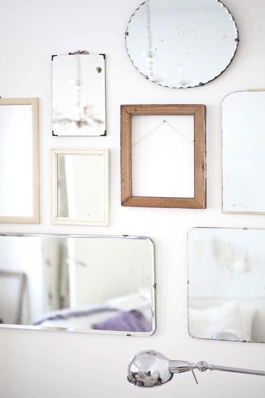 Example of how to use mirrors and lighting to enhance a space featuring a home studio with a gallery wall of mirrors