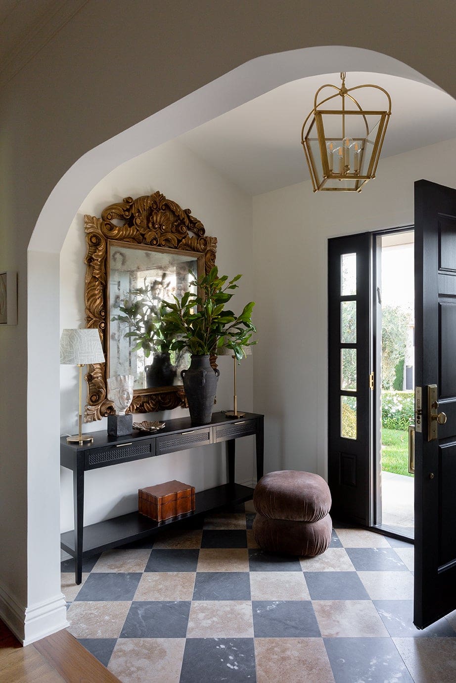Example of how to use mirrors and lighting to enhance a space featuring a entryway with large mirror in a traditional elegant style