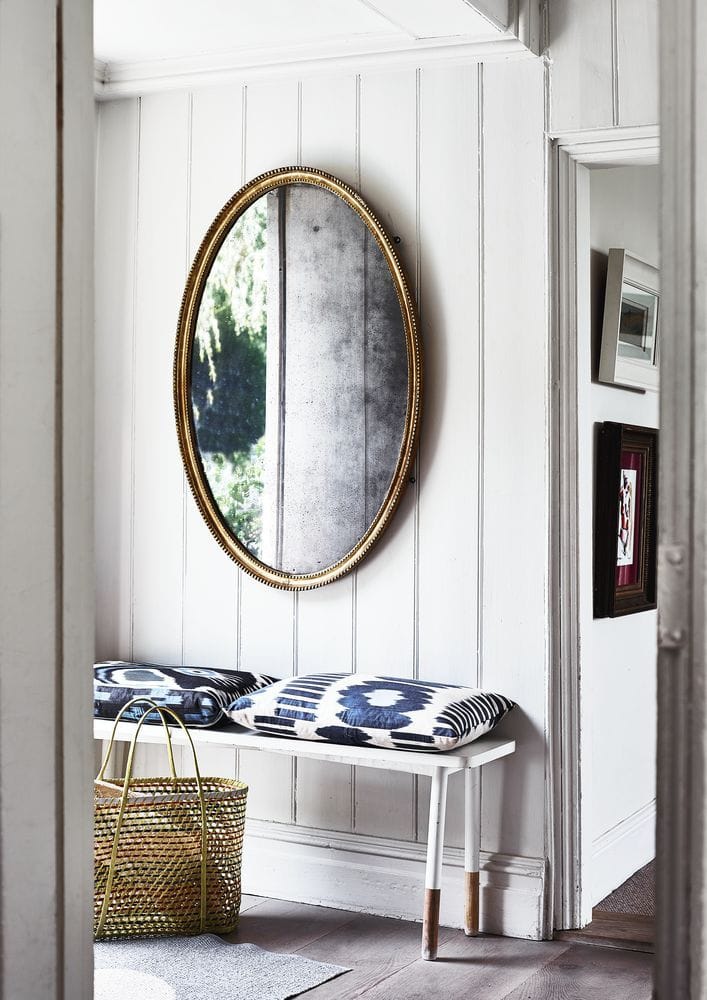 Example of how to use mirrors and lighting to enhance a space featuring a entryway with a mirror in coastal style