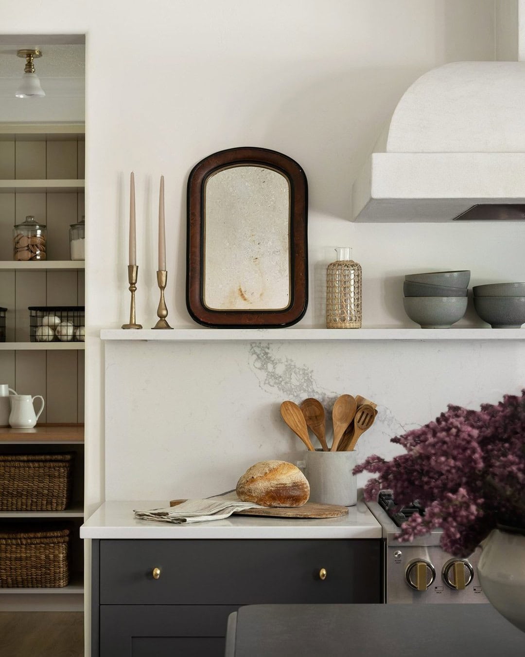 Example of how to use mirrors and lighting to enhance a space featuring a modern heirloom kitchen with a small wooden mirror