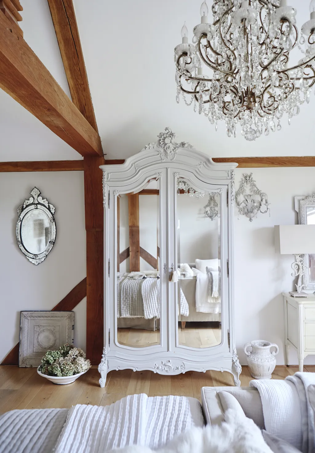 Example of how to use mirrors and lighting to enhance a space featuring a bedroom with dresser with mirrored doors in shabby chic home decor style