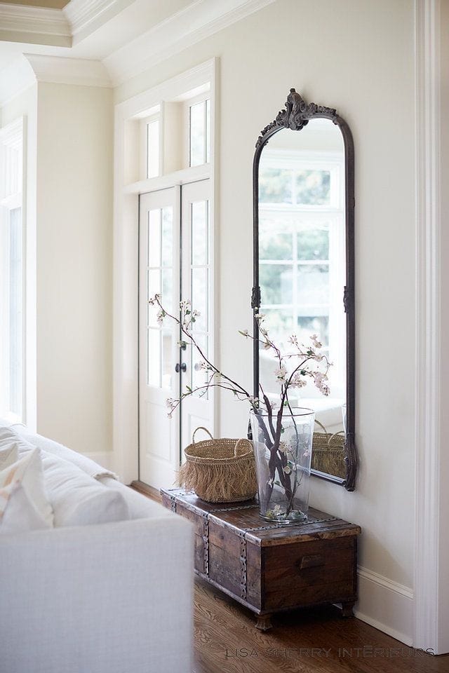 Example of how to use mirrors and lighting to enhance a space featuring a living room with a antique mirror