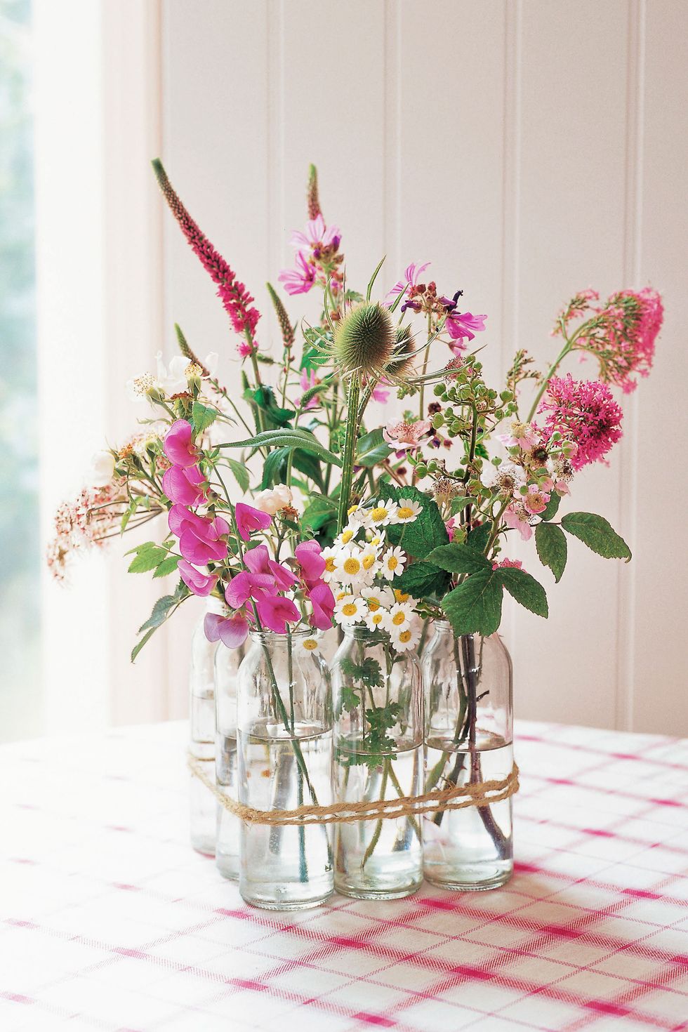 Vintage Valentine's Day decor idea featuring clear vases with pink and white floral arrangements