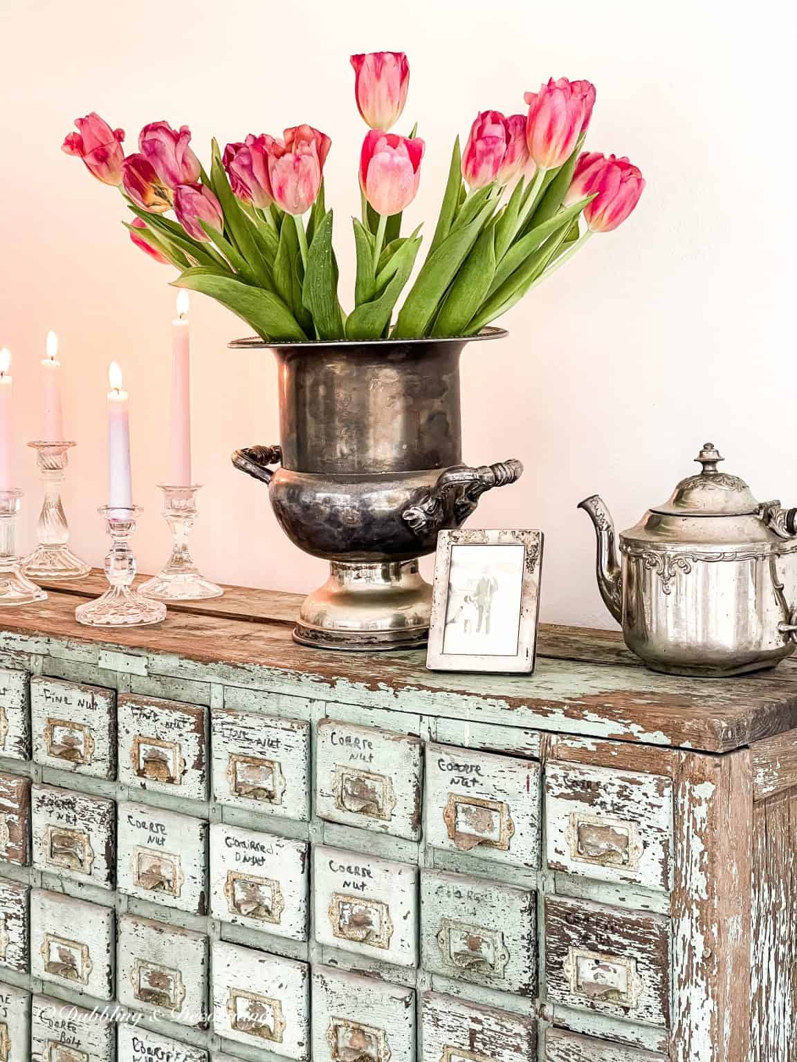 Vintage Valentine's Day decor idea featuring antique silver vases with pink floral arrangements