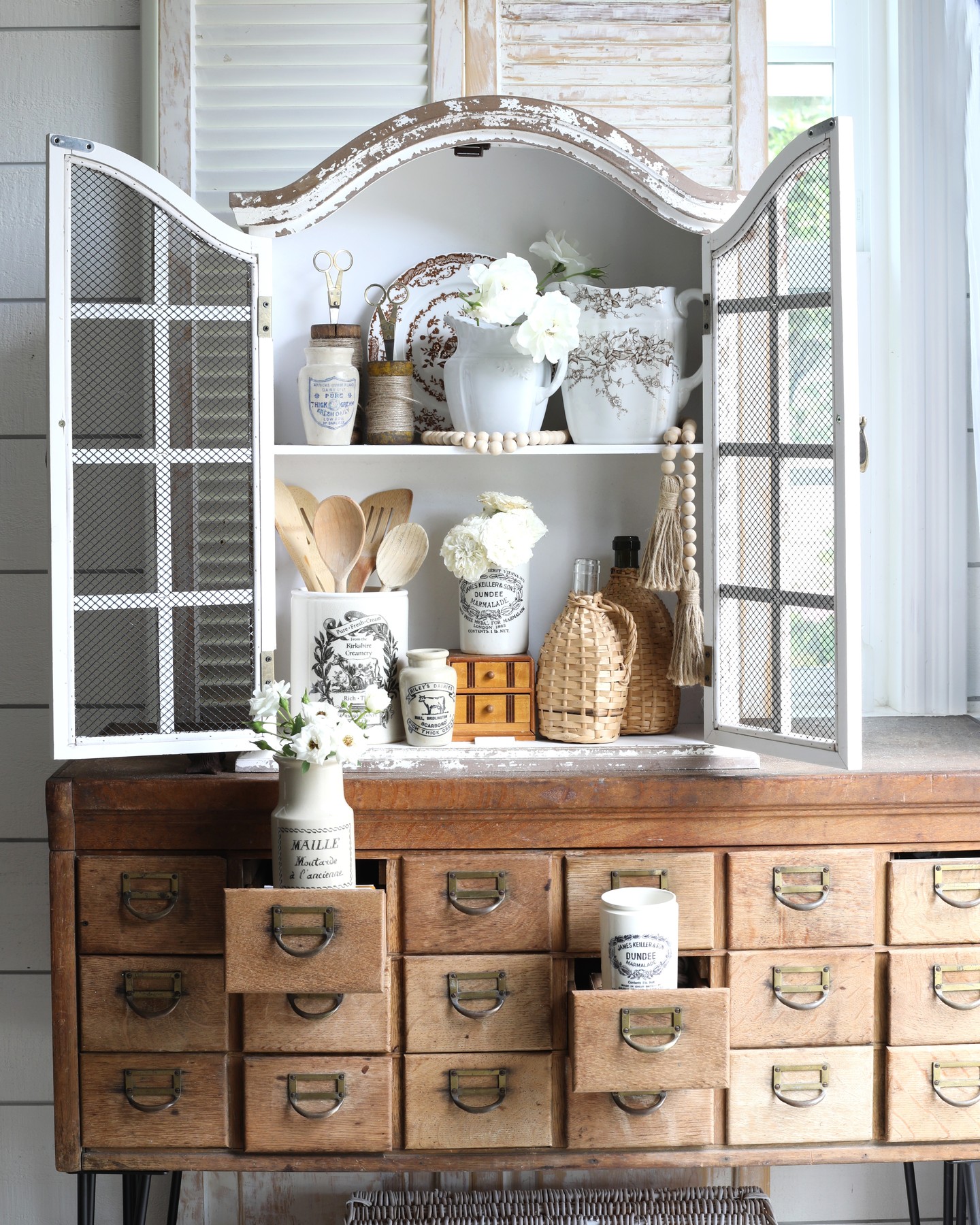 Real-life example close up cottage style kitchen decor featuring vintage mini drawer cabinet