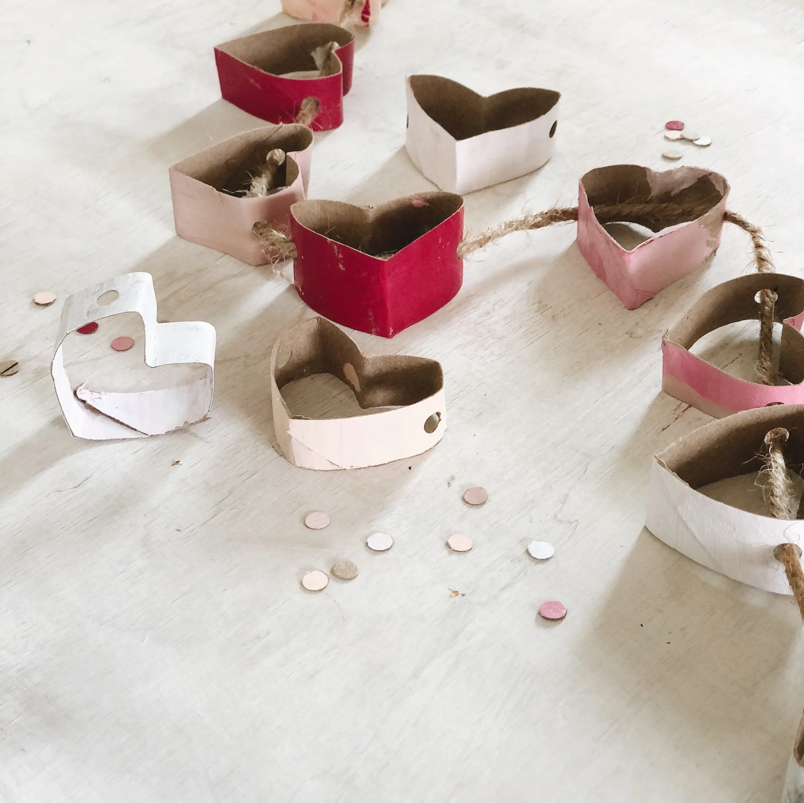 DIY Valentines kid-friendly craft idea featuring hearts-shaped garland made with toilet paper rolls