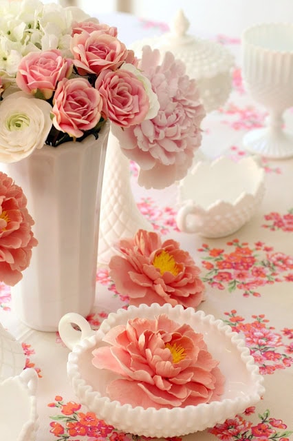 Vintage Valentine's Day decor idea featuring milk vases with pink and white floral arrangements