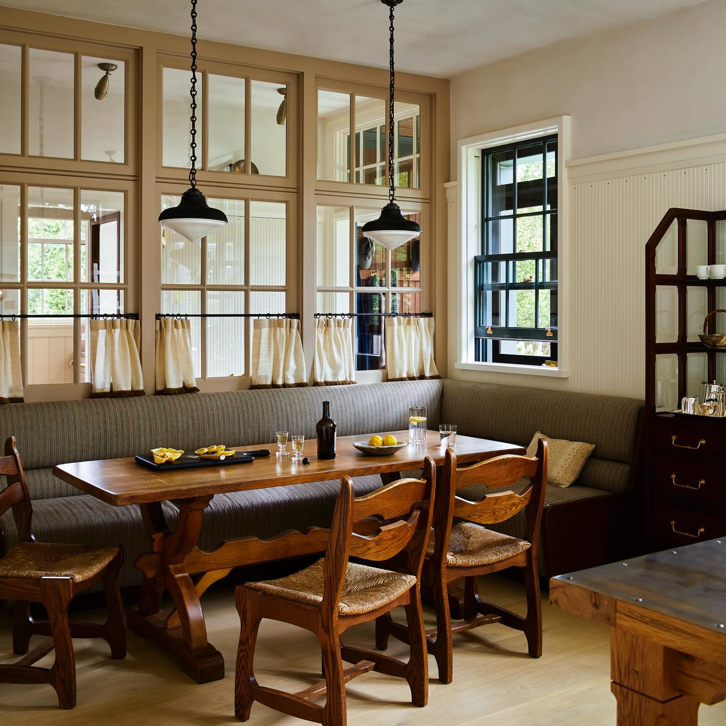 Example of modern kitchen decor trends featuring a kitchen in creamy and wood color palette with an indoor grid window and half drapes