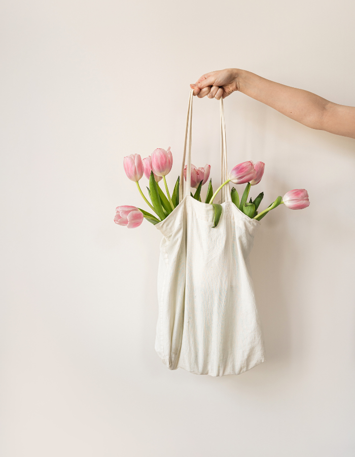 image of woman holding floral bouquet innside tote as example of Valentine's day gift ideas for her
