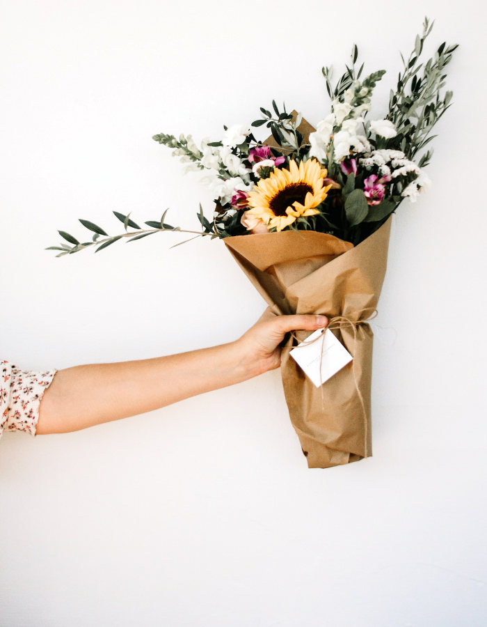 image of woman holding floral bouquet as example of Valentine's day gift ideas for her