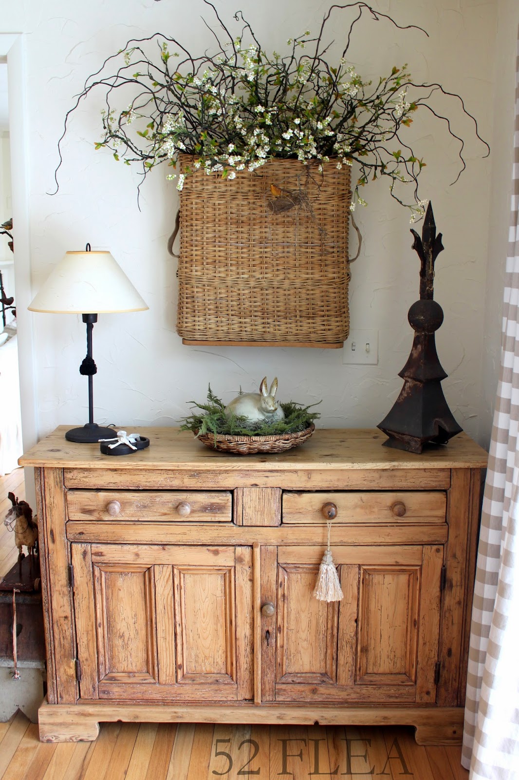 Eastern entryway table decor idea featuring a rustic option with a woven basket hung on the wall with white flowers