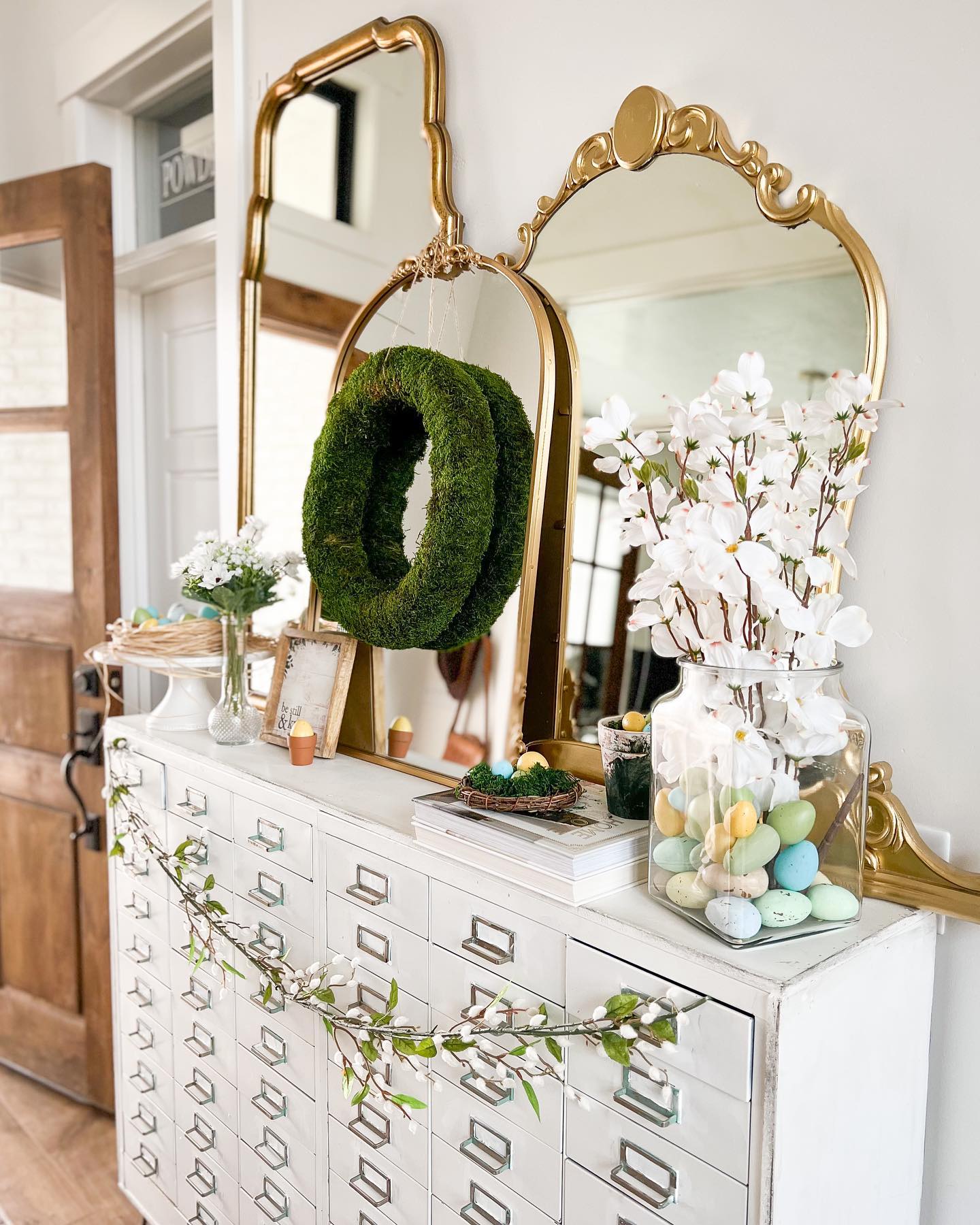 Eastern entryway table decor idea featuring a farmhouse style ith moss wreath