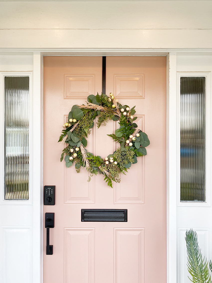 spring wreath for your front door idea featuring one with greenery against a pink door