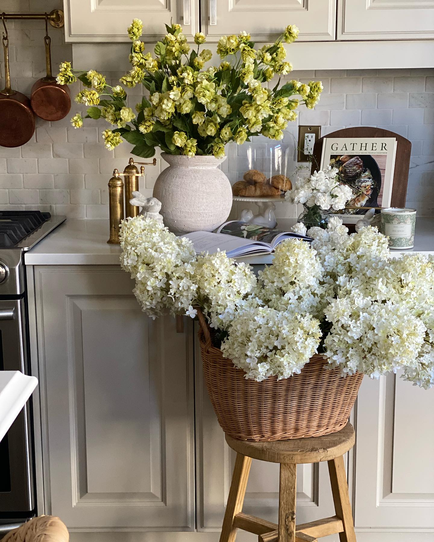 Nancy Meyers interiors inspiration example showcasing a traditional kitchen sink with comforting layered decor
