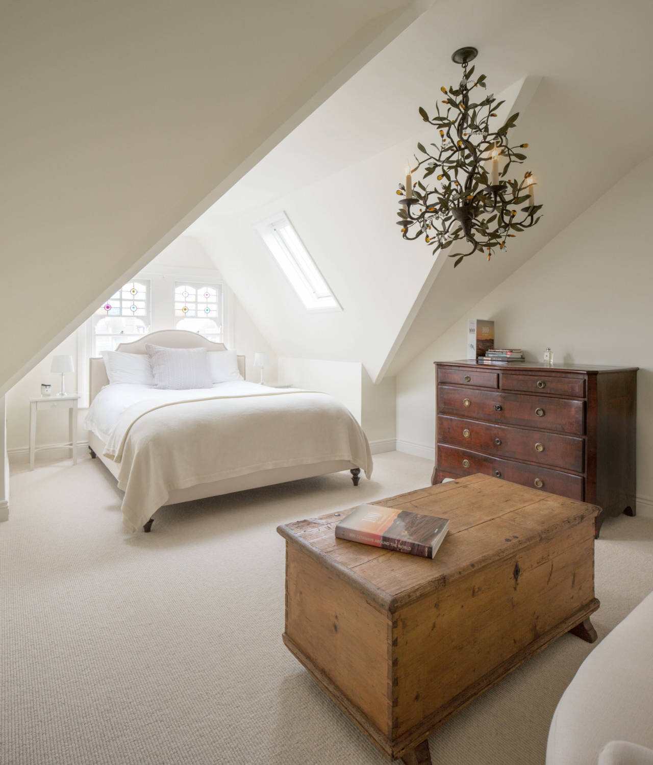 Statement pieces used as unique artworks in this bedroom featuring a large structural organic chandelier.