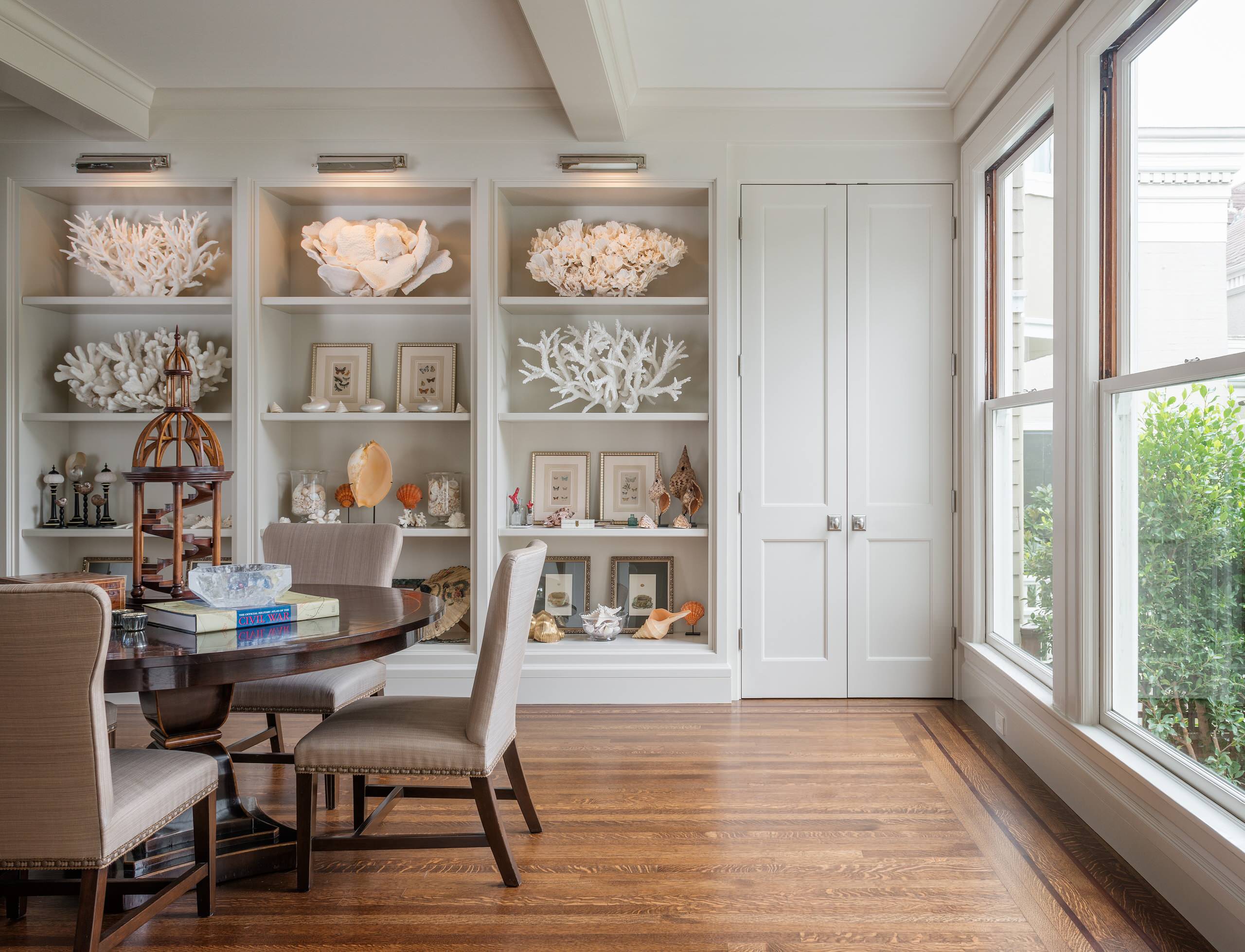 Statement pieces used as unique artworks in this living room featuring a coastal bookshelf.