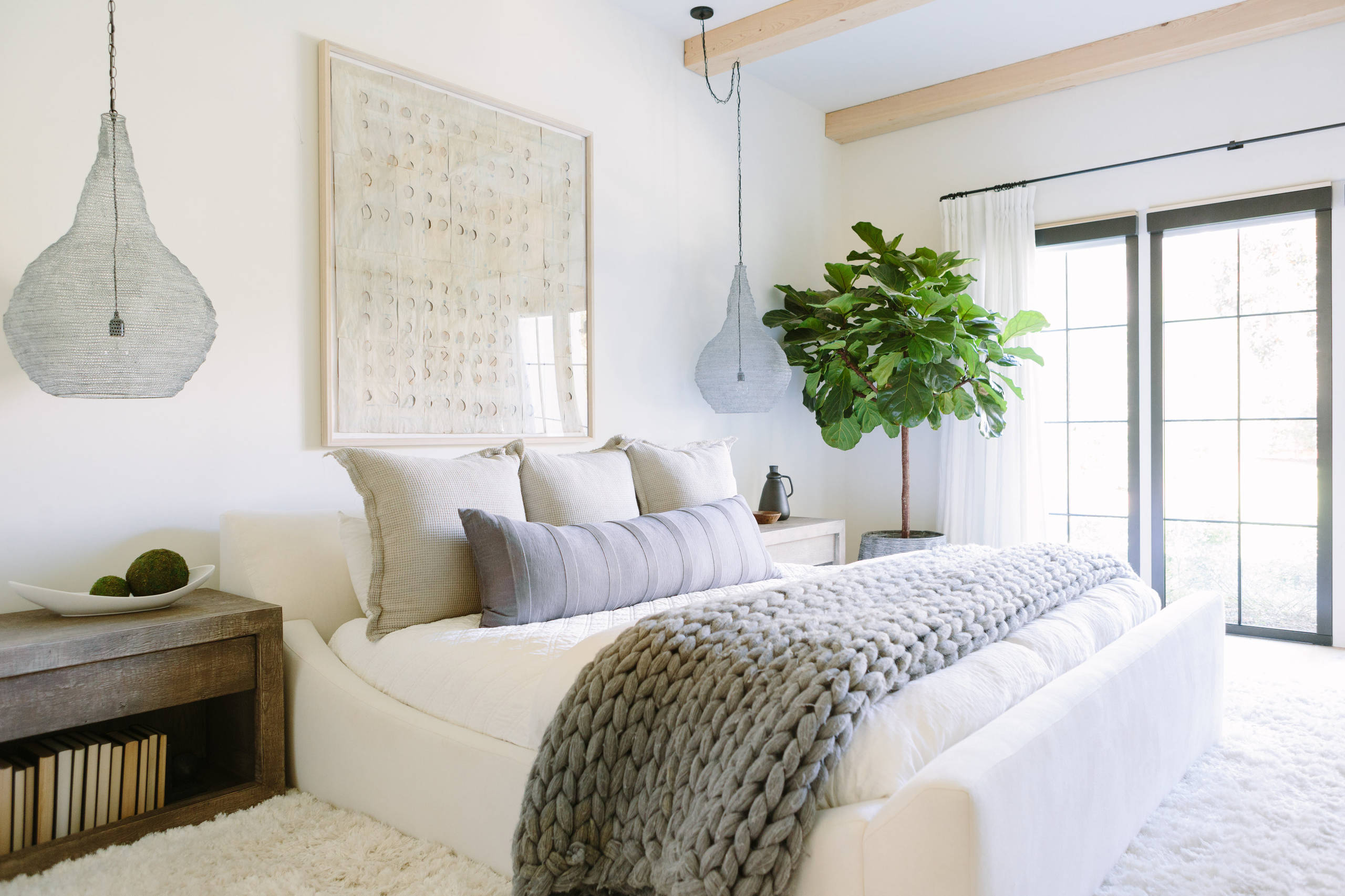 Statement pieces used as unique artworks in this bedroom featuring a coastal framed abstract painting.