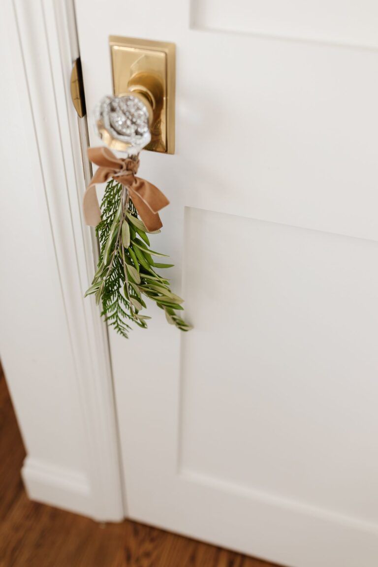 greenery tied to door handle in holiday theme budget Christmas decorating ideas